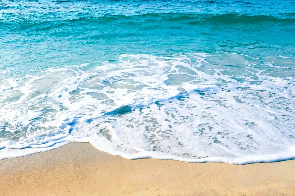 Vagues turquoise venant mourir sur le sable doré de la plage d'Erbaju