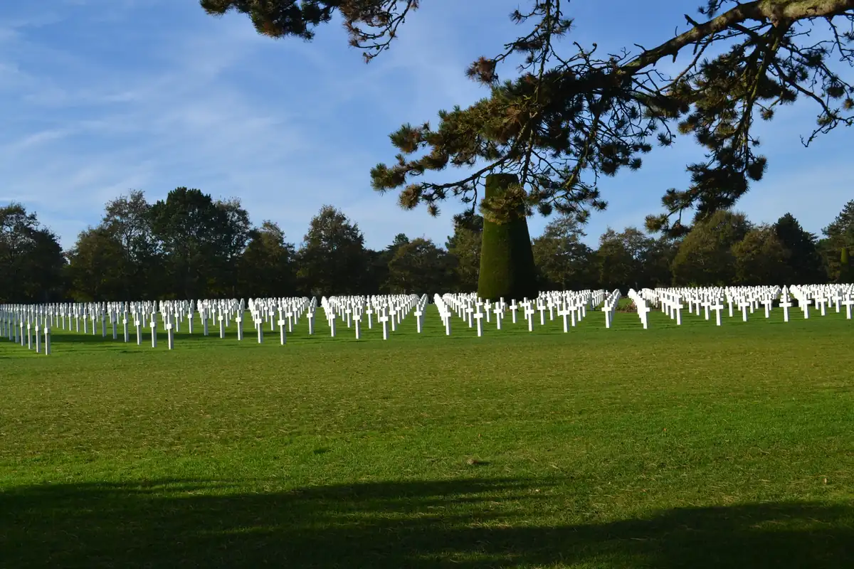Rangées de croix blanches du cimetière américain de Colleville-sur-Mer sous un ciel bleu lumineux