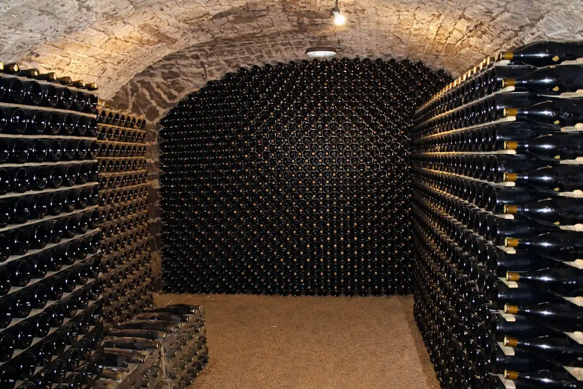Cave voûtée avec des milliers de bouteilles de vin alignées en Bourgogne