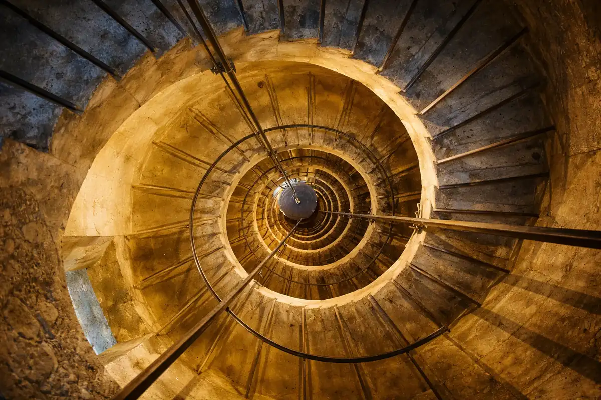 L'escalier en colimaçon de la tour du château de Joux — la pierre s'enroule sur elle-même